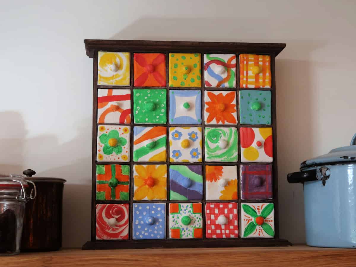 DIY Spice Chest made from an advent calendar box and air-dried clay. This easy craft tutorial turns a plain wooden advent calendar box into a gorgeous spice chest with clay fronted drawers decorated with acrylic paints. Perfect for holding spices or little knick-knacks.